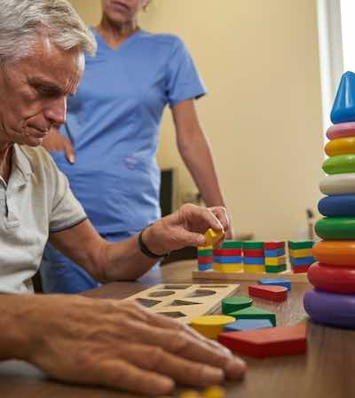 An occupational therapist supporting a patient with a mobility exercise